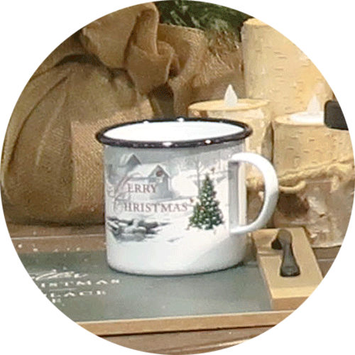 A white mug with a snowy outdoor scene that says Season's Greetings.